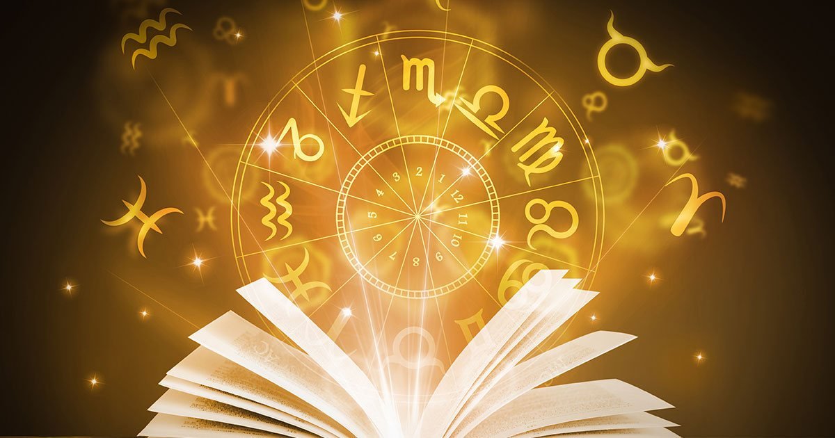 Open book with a glowing golden zodiac wheel and astrology signs